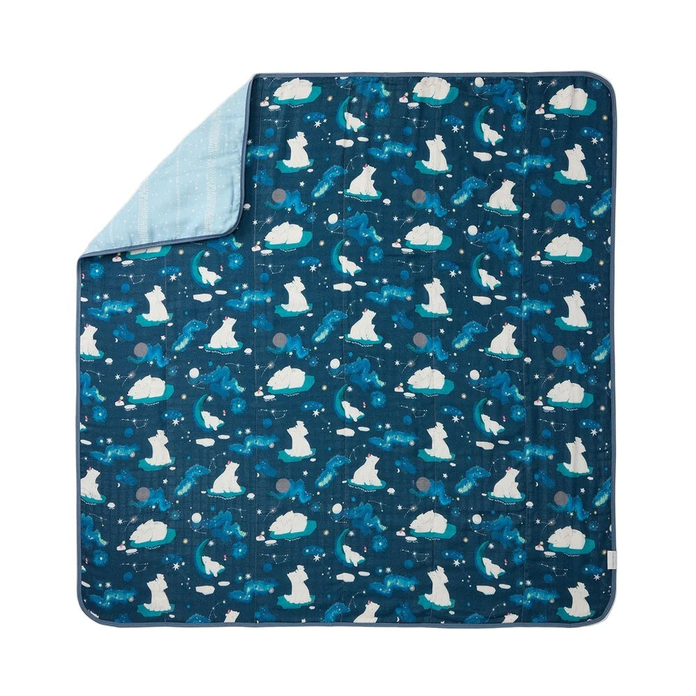 LOULOU LOLLIPOP Muslin Quilt Blanket in navy with polar bears and stars, laid flat with soft blue reverse folded at corner.