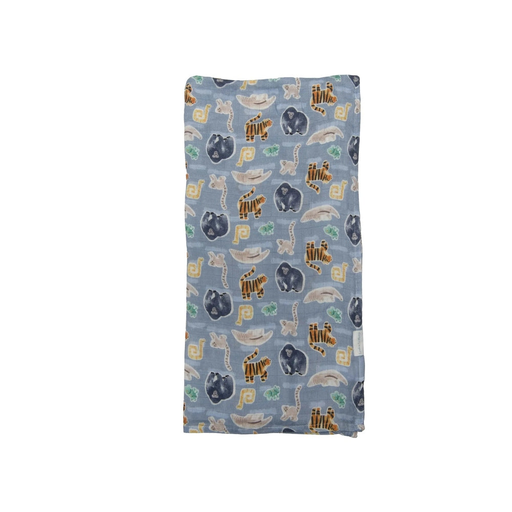 Loulou Lollipop Muslin Swaddle in blue jungle animal print laid flat.