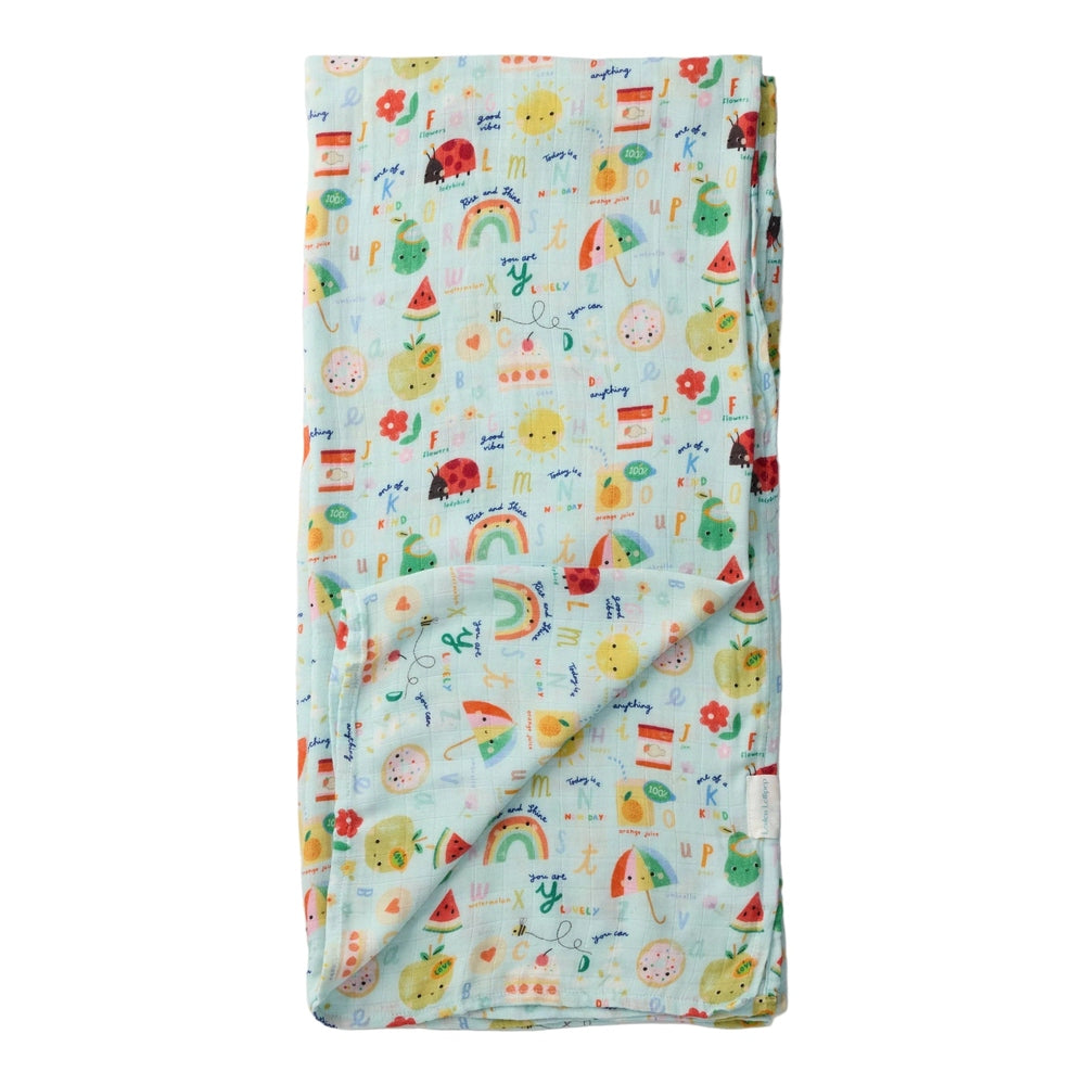 LOULOU LOLLIPOP Muslin Swaddle in pastel mint with fruit print, softly folded to show lightweight, breathable fabric.