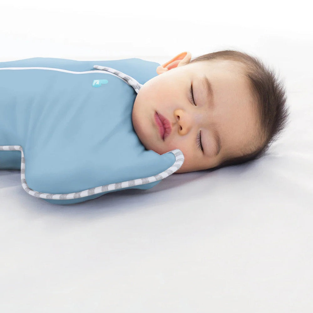 Love To Dream Swaddle Up Original Cotton 1.0 Tog Dusty Blue keeps a baby peacefully asleep with arms up.