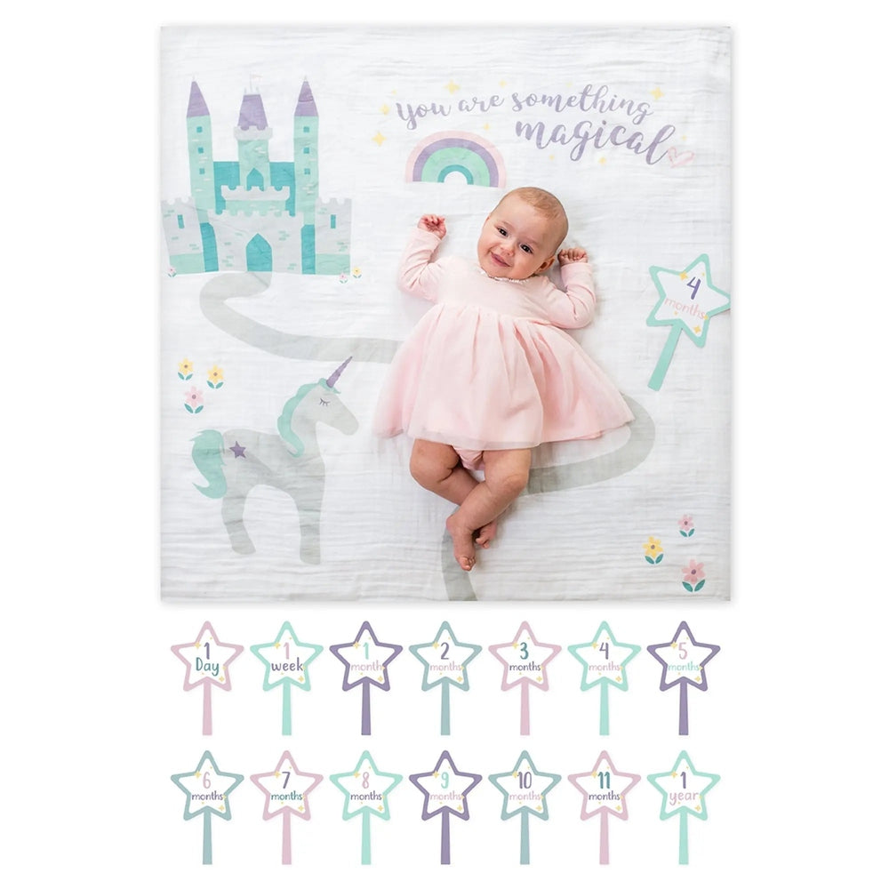 Lulujo Baby's 1St Year Set: baby girl in pink dress lying on pastel unicorn/castle backdrop with 12 milestone star cards.