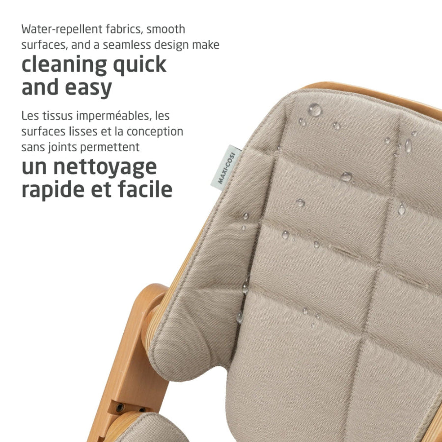 MAXI COSI Nesta 3-in-1 High Chair, beige water-repellent fabric, wooden frame, droplets bead on seat.