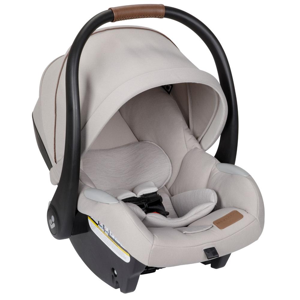 Maxi-Cosi Zelia Luxe 5-In-1 infant car seat in beige with a curved black frame and brown grip handle