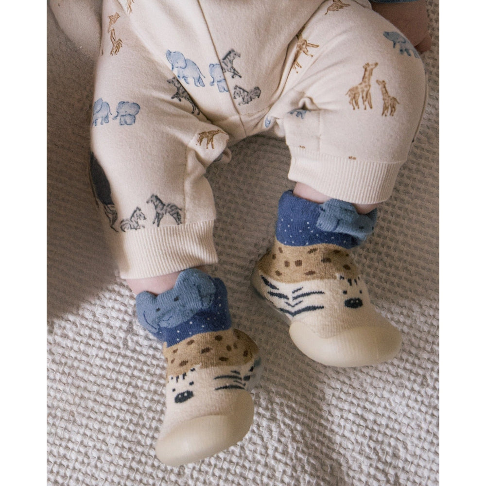 Mayoral Newborn Baby Slipper Socks—cream with tiger face and blue cuffs on a baby's feet.
