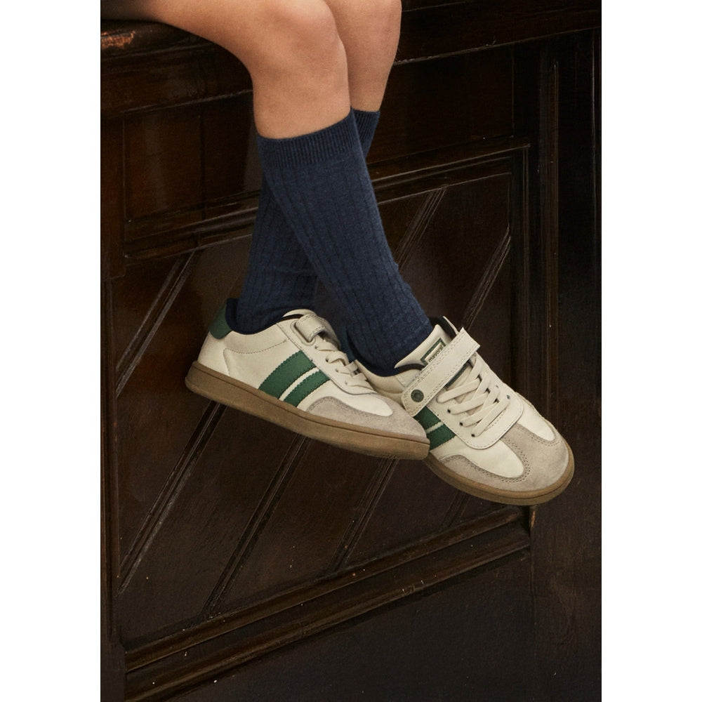 Mayoral Trainers Natural toddler sneakers with beige suede, green stripe, and Velcro strap, worn on navy socks.