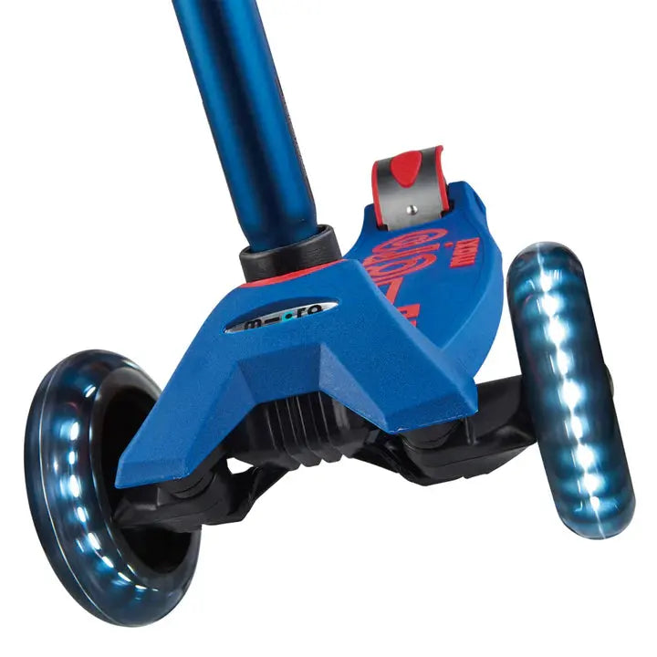 Micro Maxi Deluxe LED scooter, blue deck with light-up wheels, in motion.