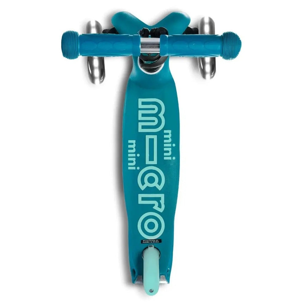 Micro Mini Deluxe LED Scooter in teal with blue handlebars and light-up wheels, shown ready to ride.