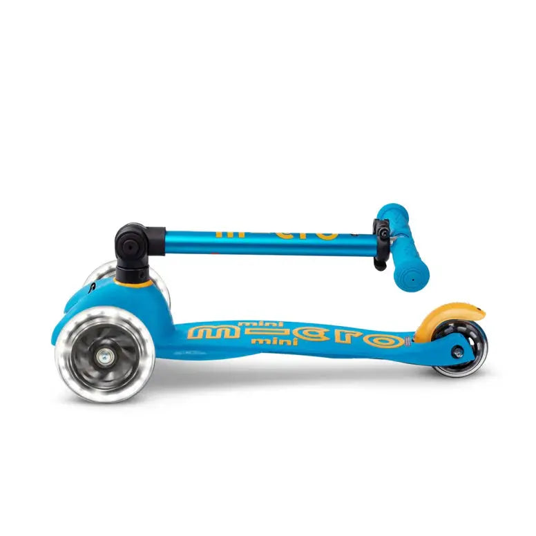 Micro Mini Deluxe Scooter blue with orange accents, folded compactly with handlebar lowered for easy transport.