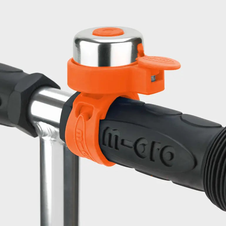 Micro scooter bell mounted on orange clip attached to handlebars with black grip (MICRO).