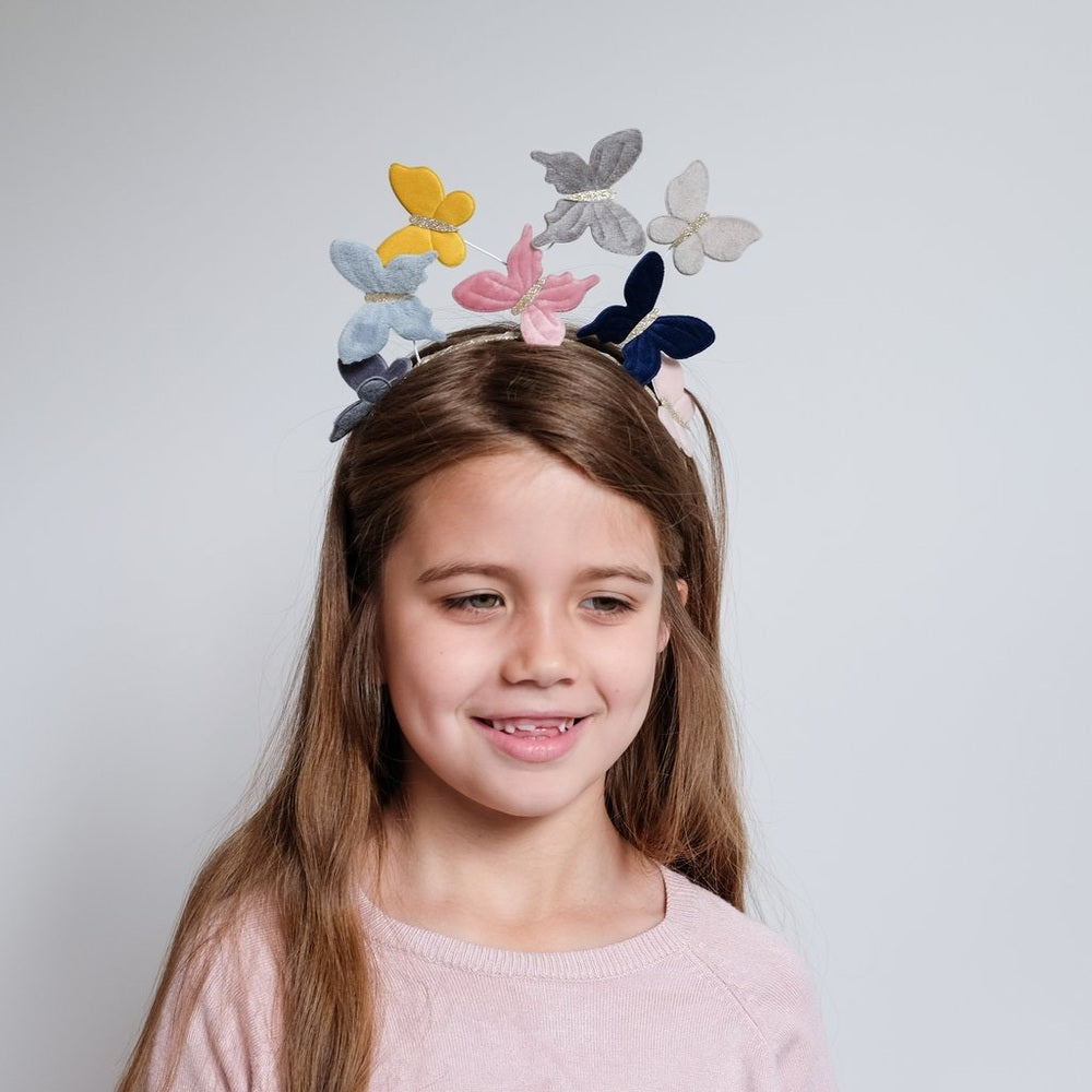 Mimi & Lula Velvet Butterfly Headband with multicolor felt butterflies on a smiling girl
