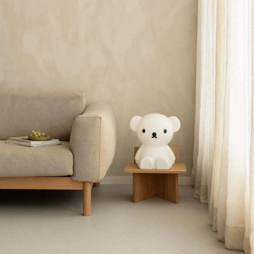 Mr Maria Star Light Boris bear night light, white ceramic, on a small wooden table beside a beige sofa.