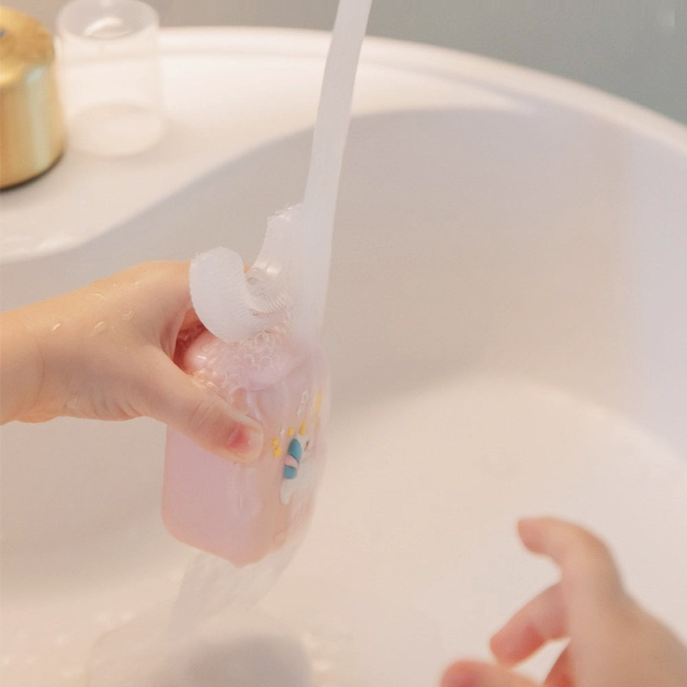 Nemibaby Kids U-Shape Toothbrush, pink, being rinsed under running water