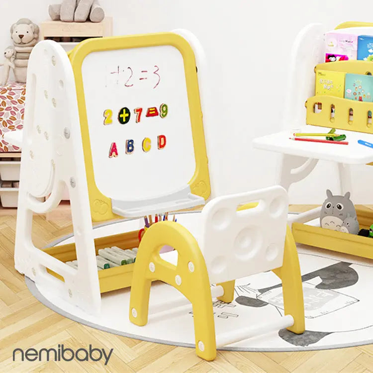 Nemibaby Multi Function Easel & Bookshelf in white and yellow, child writes on the whiteboard while books sit on open shelves.