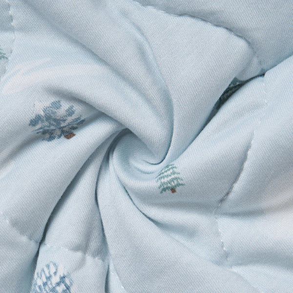 Nest Designs Bamboo Jersey Cozy Blanket Medium Snowy Snuggles, light blue with palm-tree motifs, twisted to reveal plush fabric