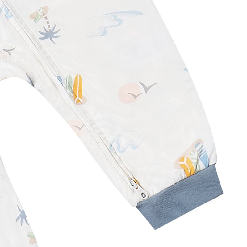 Nest Designs Bamboo Jersey Zip-Footless Baby Sleeper in pastel waves with blue cuffs; visible front zipper along the sleeve.