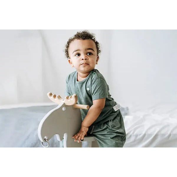 Nest Designs Bamboo Jersey Short Sleeve Footed Sleep Bag 0.5 Tog Pantone Harbor Grey: baby sits on a wooden rocker wearing the sleep bag.