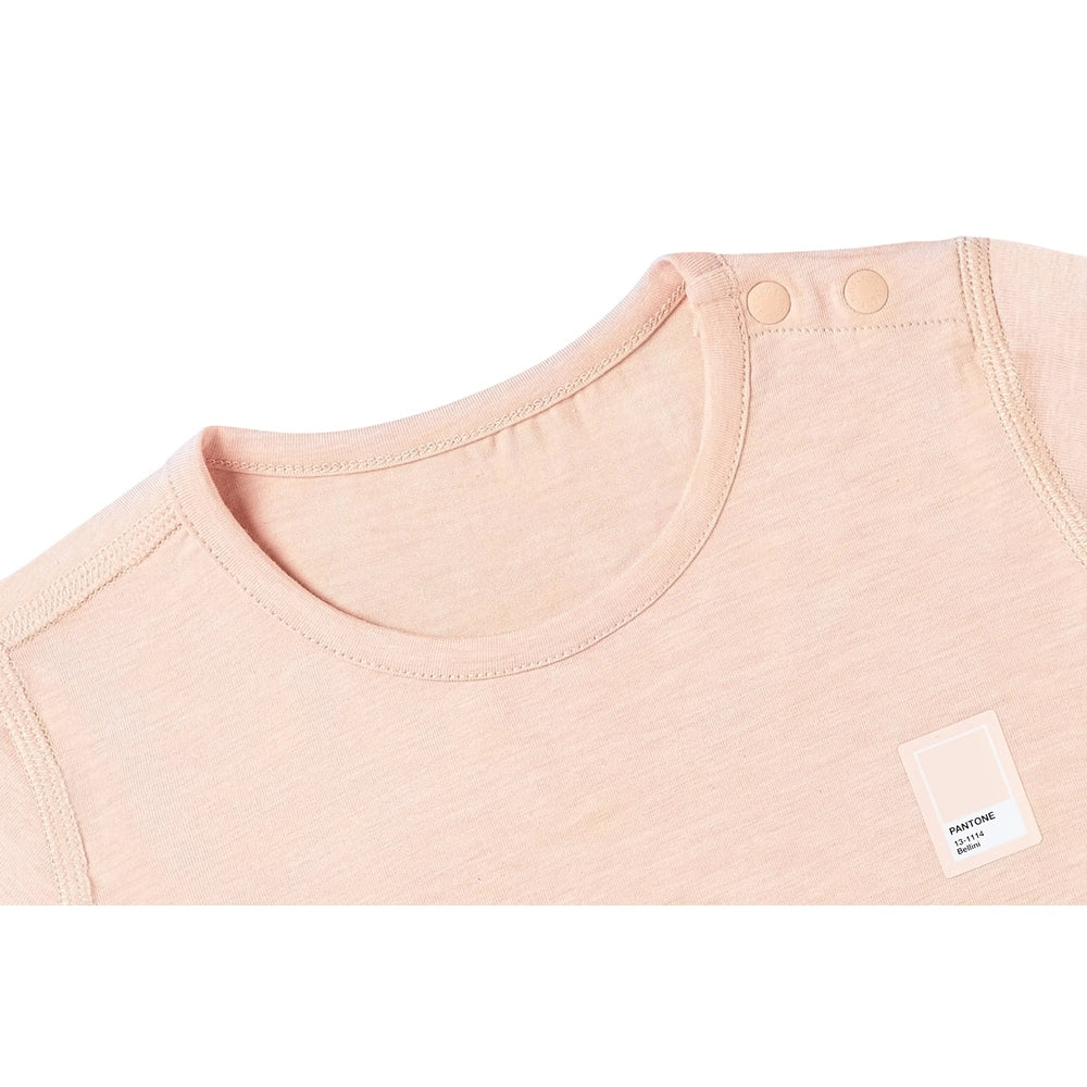 Nest Designs bamboo jersey short-sleeve T-shirt in Pantone Bellini with snap shoulder buttons visible.