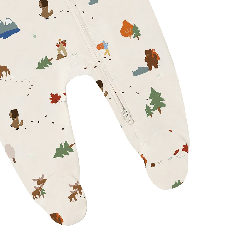Nest Designs Timber long-sleeve footed sleeper in cream with woodland print; front-to-ankle zipper for easy changes.