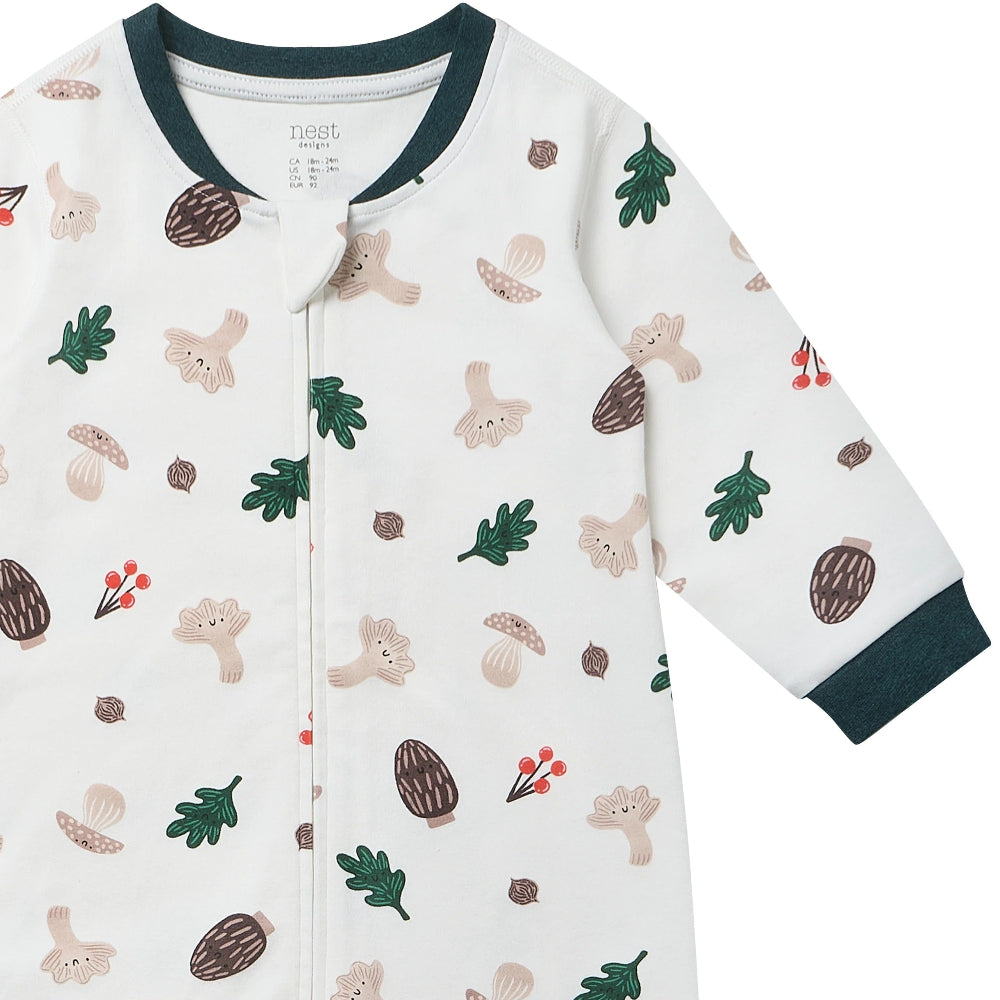 Nest Designs Forest Forage long-sleeve baby romper, white with woodland print and green cuff trim.