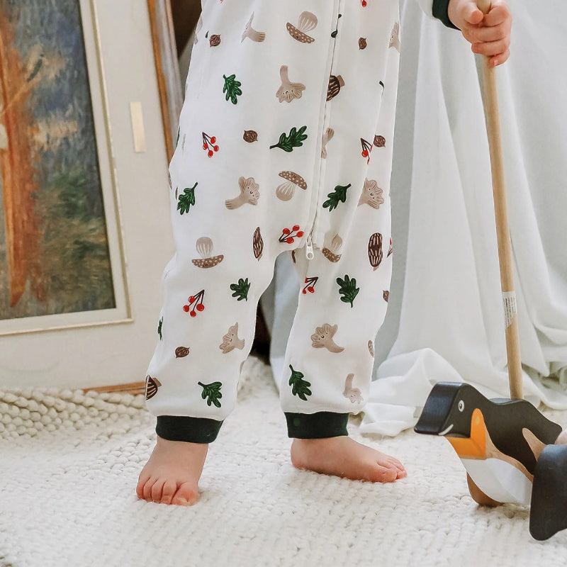 Nest Designs forest forage long-sleeve baby romper, white with woodland print in green, brown, red.