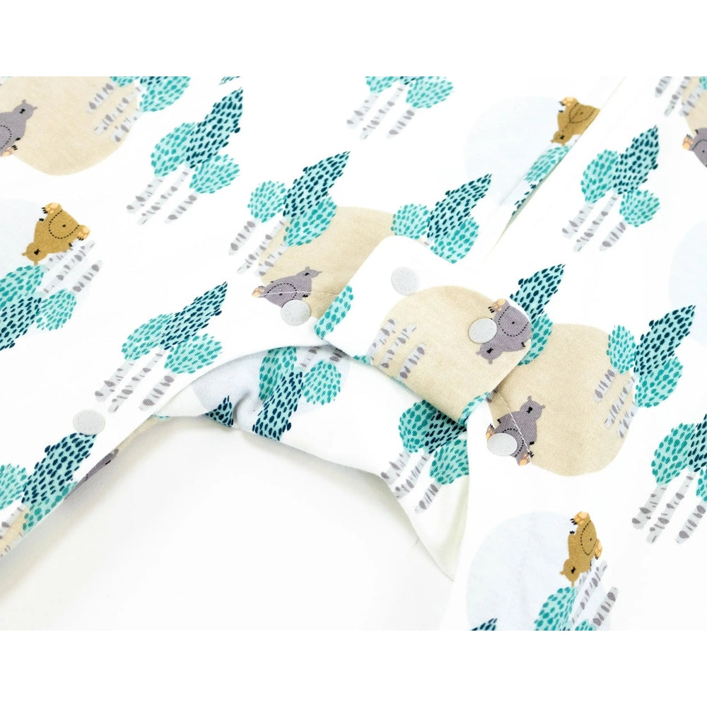 Nest Designs Organic Cotton Long-Sleeve Sleep Suit 1.0 Tog Where's The Bear in teal tree print, closed with visible snaps.