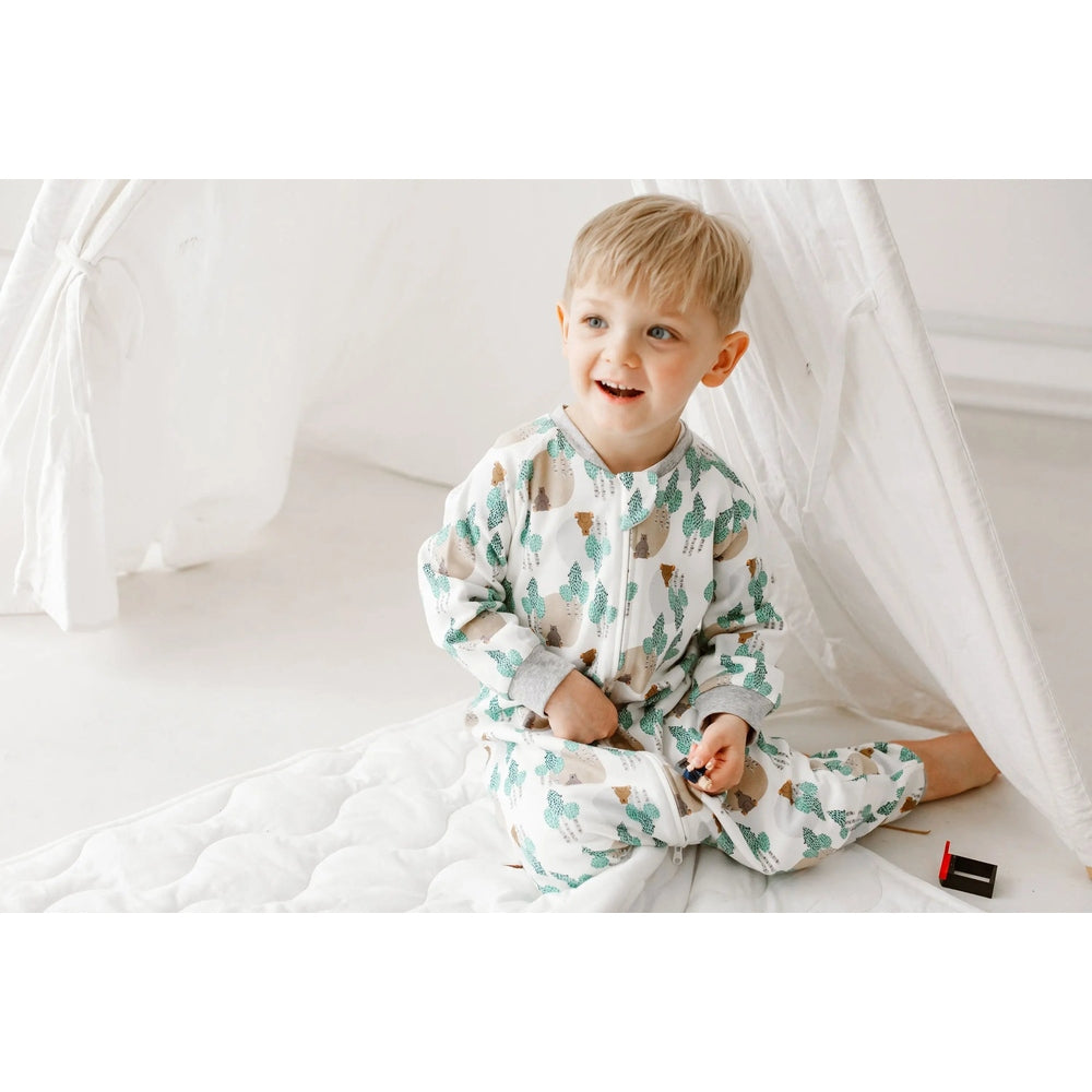 Nest Designs Organic Cotton Sleep Suit 1.0 Tog Where's The Bear; white with bear/teal cactus print, toddler smiles inside a white tent.