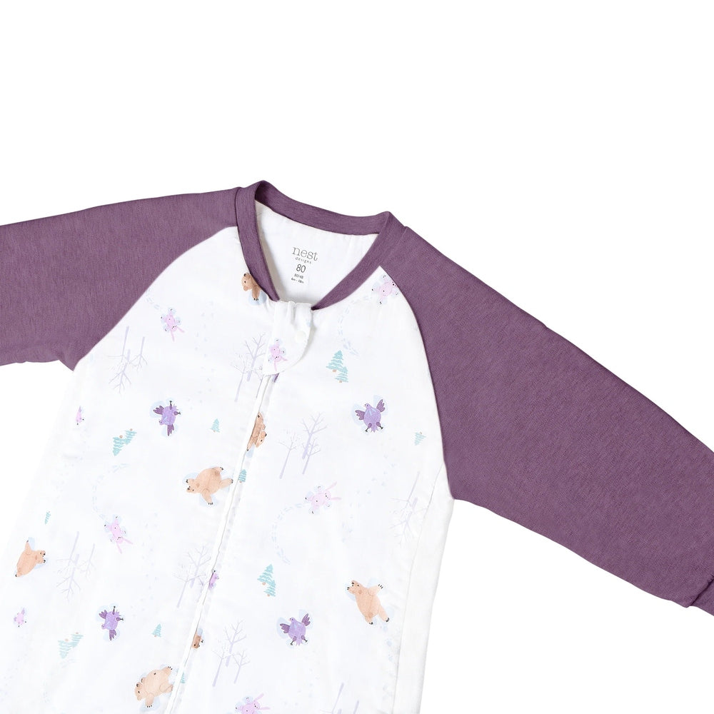 Nest Designs Raglan Bamboo Long Sleeve Footed Sleep Bag 2.5 Tog Snowy Angels laid flat showing lavender sleeves and snowy print.