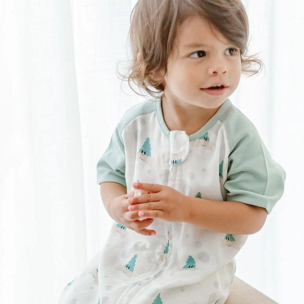 Nest Designs Raglan Bamboo Pima Short Sleeve Sleep Suit 0.6 Tog The Happy Hermit, mint green with teal trees, toddler claps by bright window