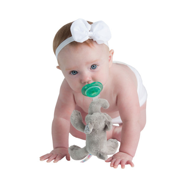Nookums Paci-Plushies Ella Elephant Buddies pacifier with a gray elephant plush companion; crawling baby reaches forward.