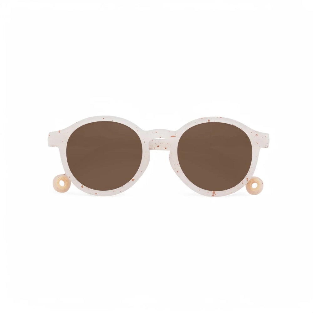 Olivio & Co Oval Sunglasses Kids Gelato Summer Vanilla Brownie resting flat with speckled white frame and brown lenses