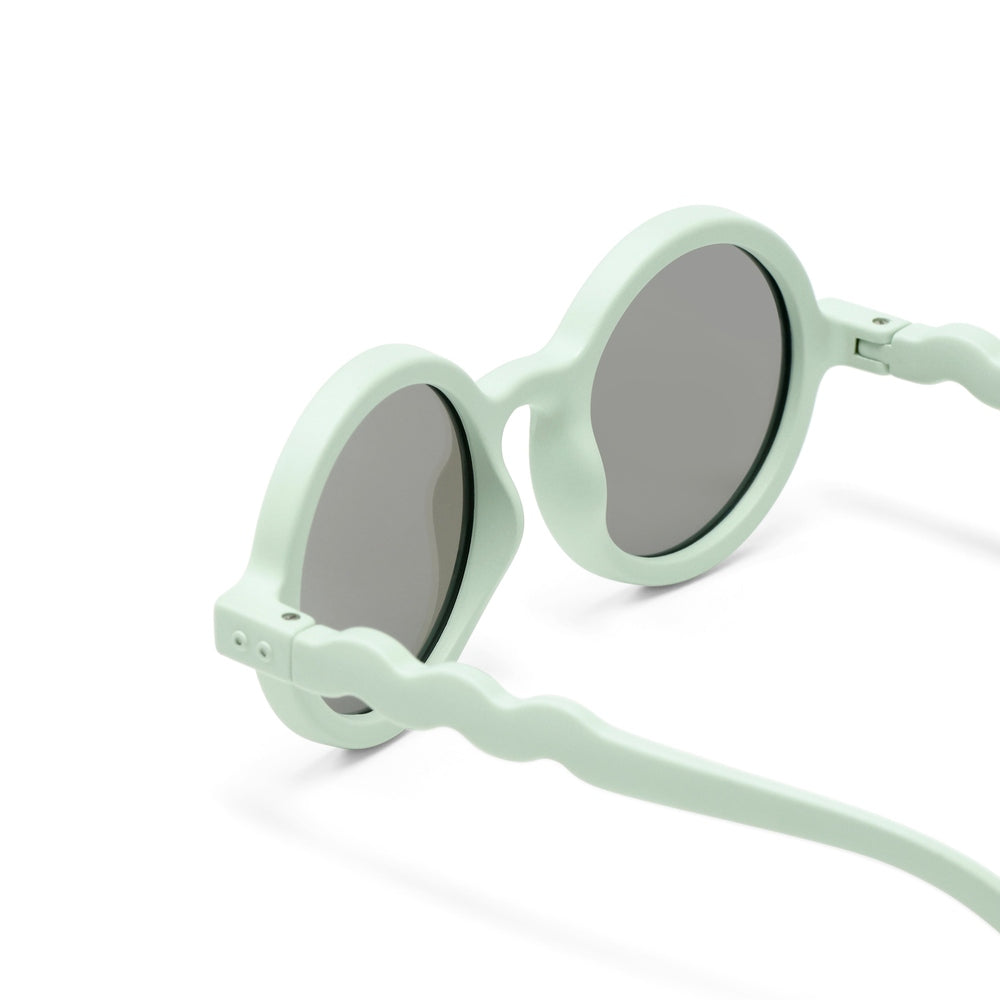 OLIVIO & CO Round Sunglasses Kids pastel mint green with gray lenses; wavy arms extend from rounded frames.
