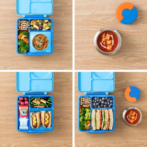 Omiebox Version 2 blue lunch box with divided compartments, open and packed with veggies, pasta, and fruit.