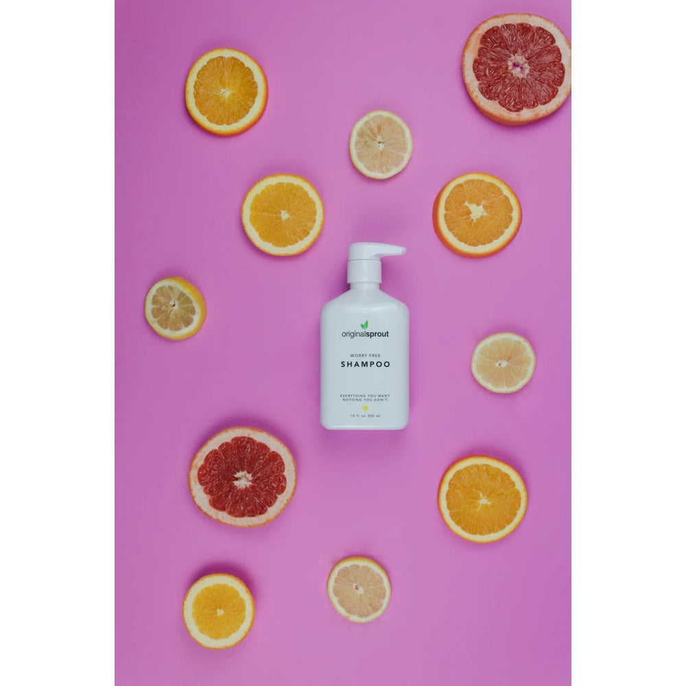 Original Sprout Worry Free Shampoo 10 oz bottle with pump among citrus slices on pink background