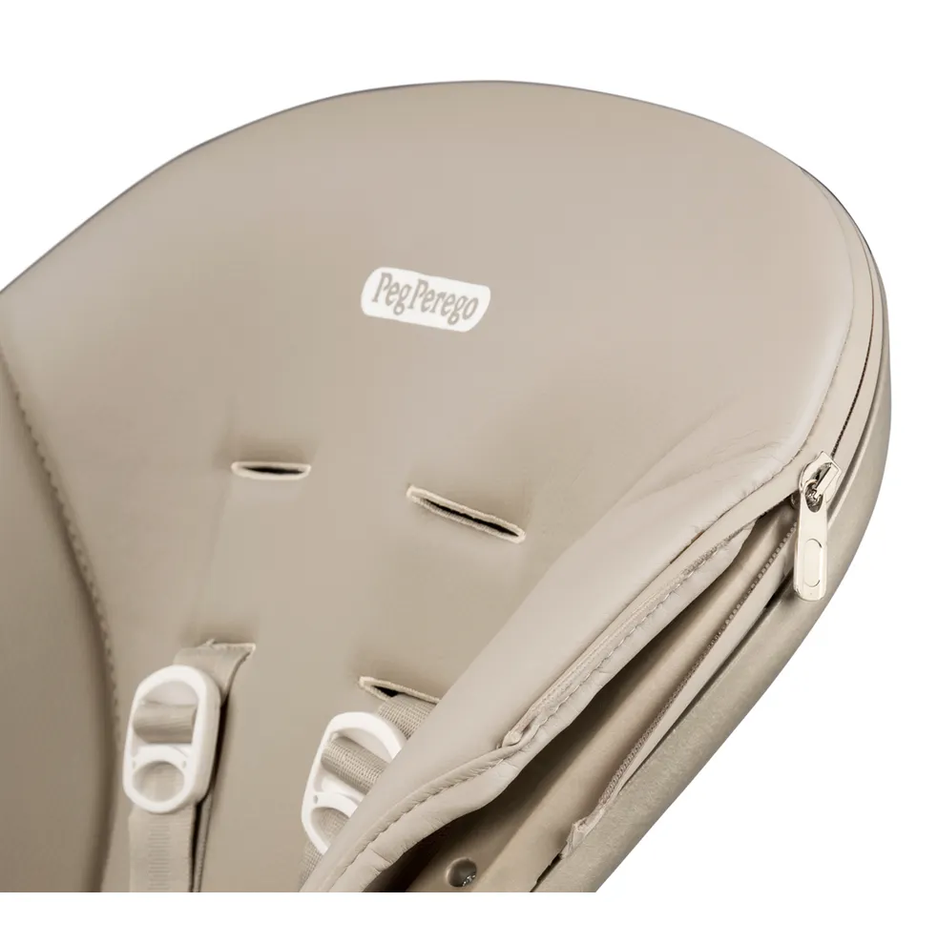 Peg Perego Living High Chair beige padded seat with white harness buckles and zipper detail.