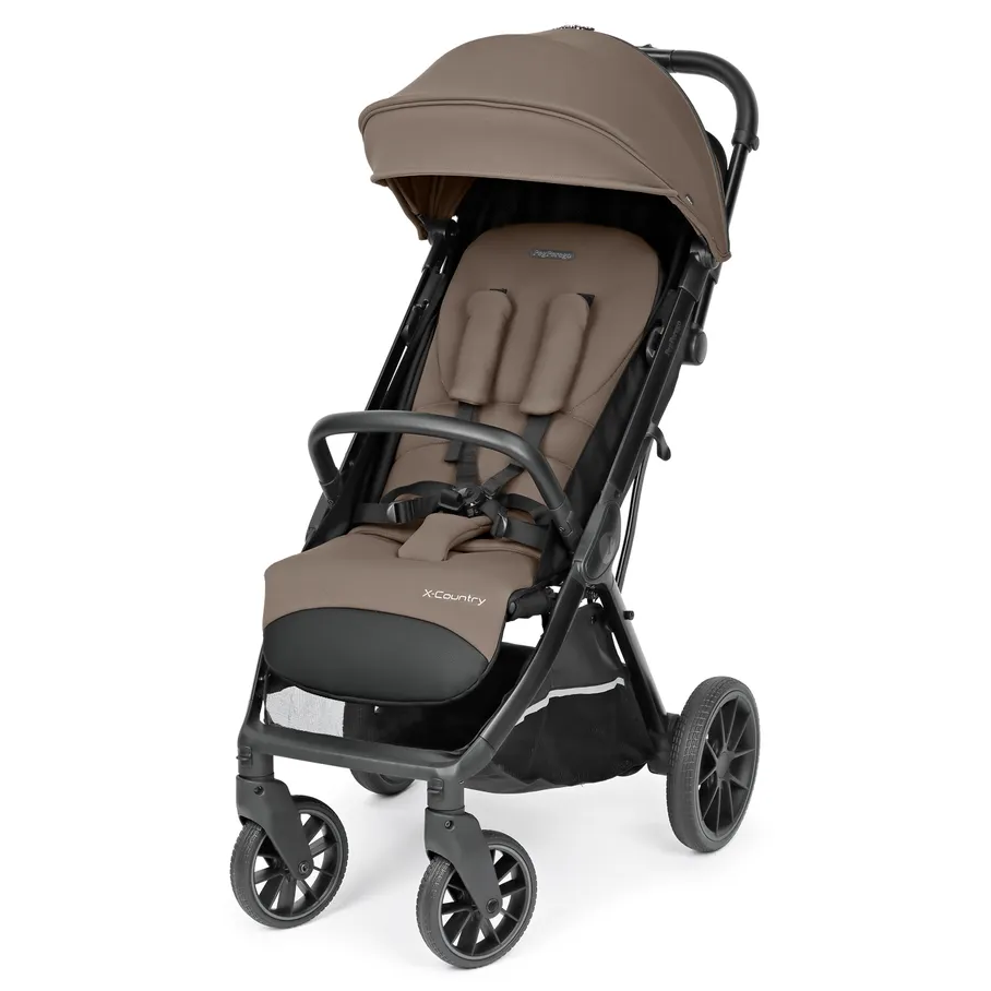 Peg Perego X-Country Travel Stroller in tan with adjustable canopy and 5-point harness secured, rugged wheels.