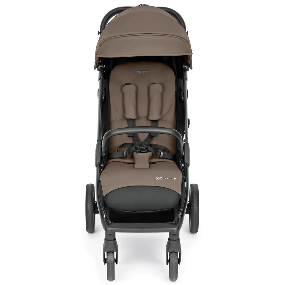 Peg Perego X-Country Travel Stroller in brown/black with 5-point harness, ready to roll as straps are secured.
