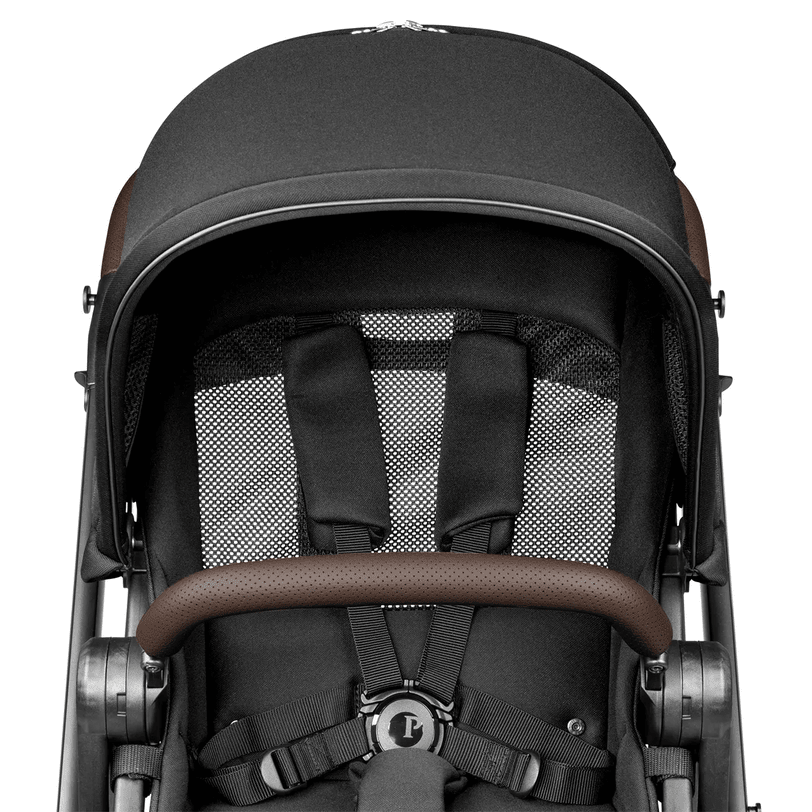 Peg Perego YPSI Stroller in charcoal gray with brown faux-leather handle, showing its 5-point harness.