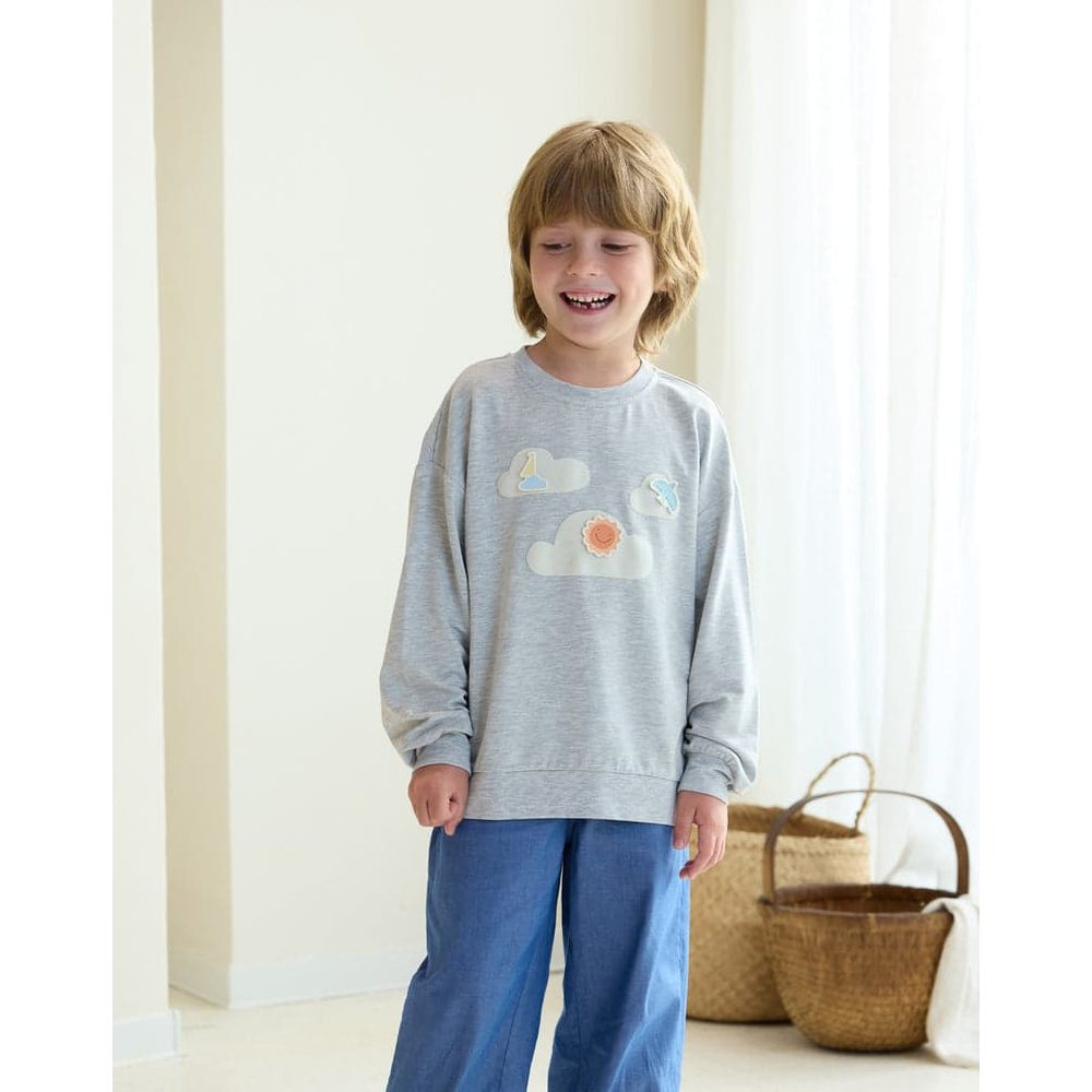 Petite Revery French Terry drop-shoulder sweatshirt, fog grey, worn by a smiling child with cloud motifs.