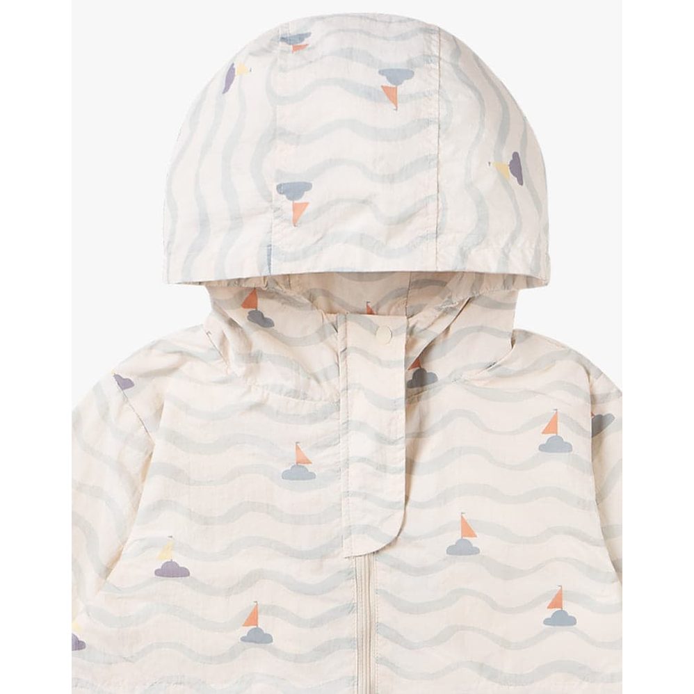 Petite Revery Hooded Windbreaker Sea La Vie in pale beige with wave pattern and sailboats, hooded and zipped.
