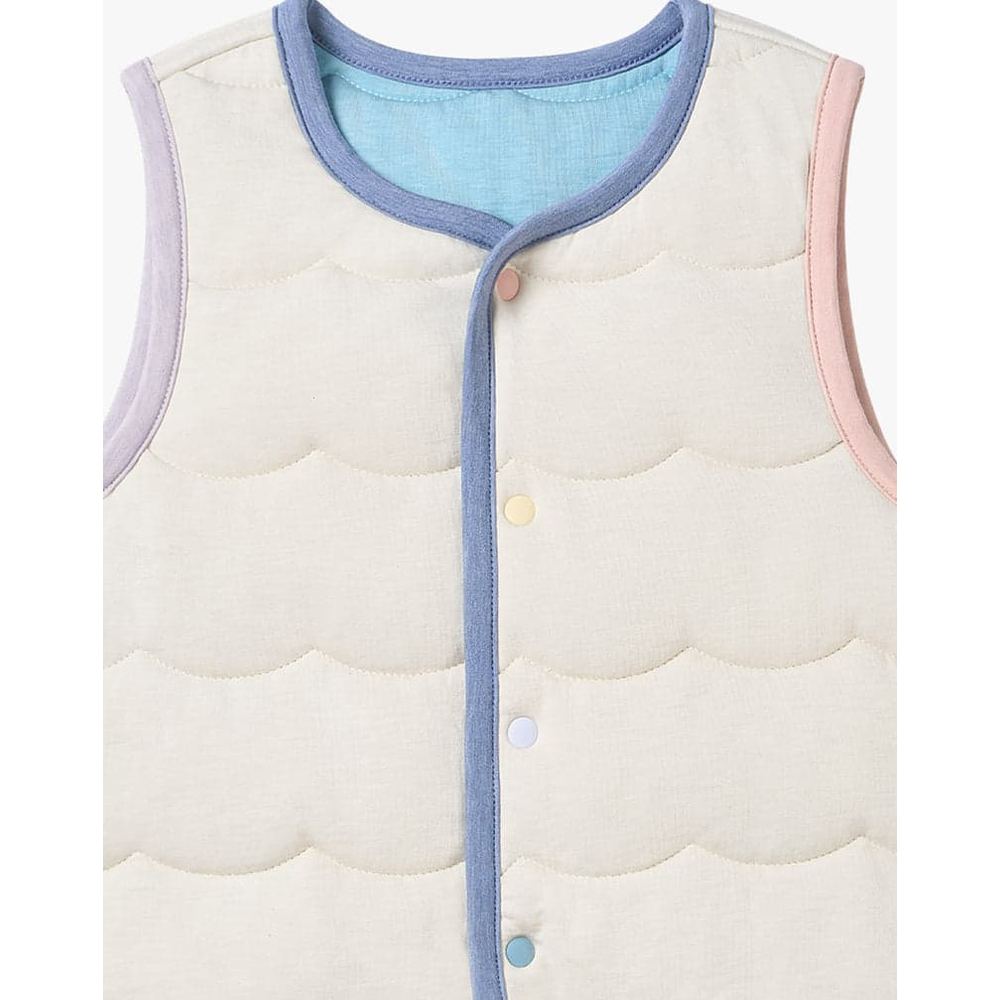 Petite Revery Quilted Sea Vest Jet Stream in cream with blue piping and pastel snaps, shown closed.