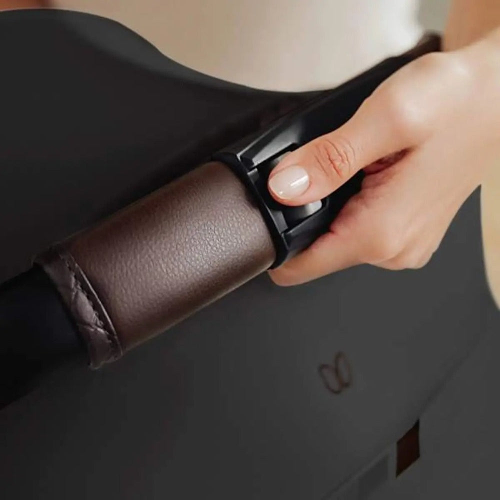 ROMER Juni Infant Car Seat with Versa Base, being secured by hand to a dark base for easy installation.