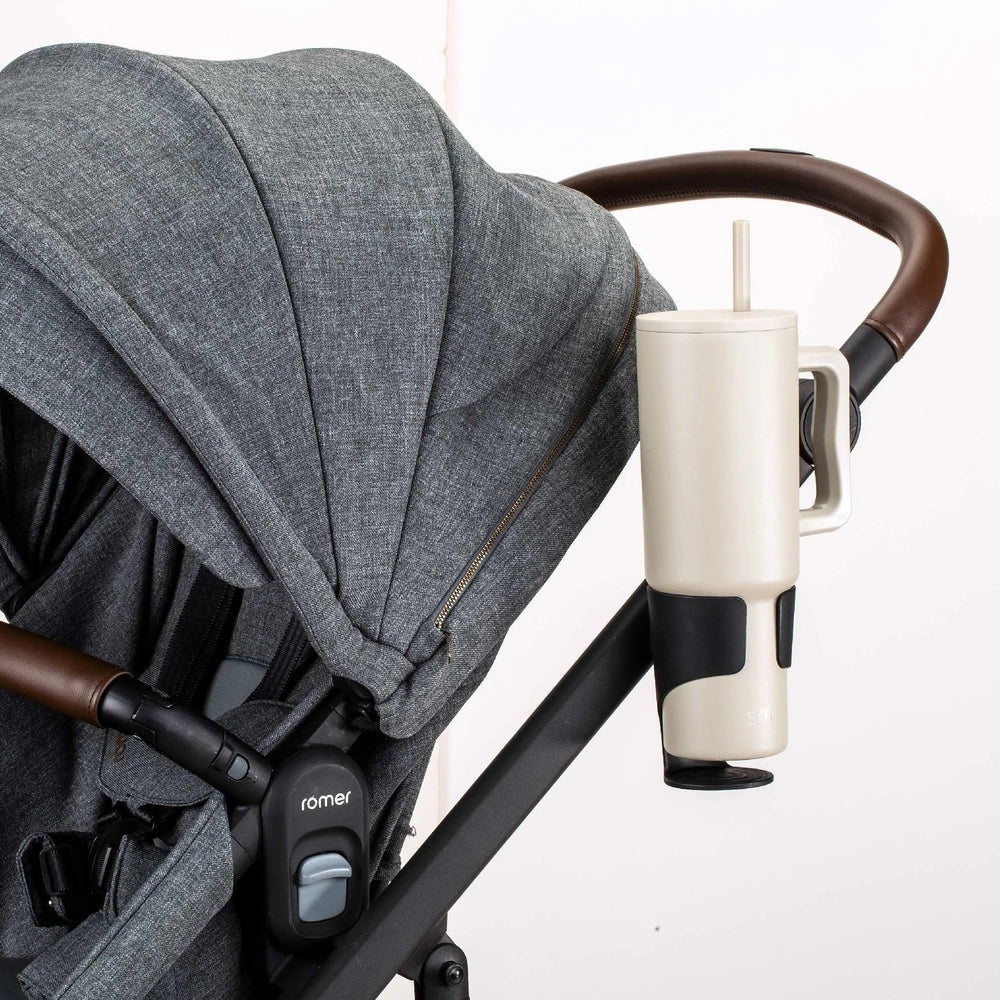 Romer Tura Cup Holder on gray ROMER stroller, beige cup holder with straw mounted on the handlebar.