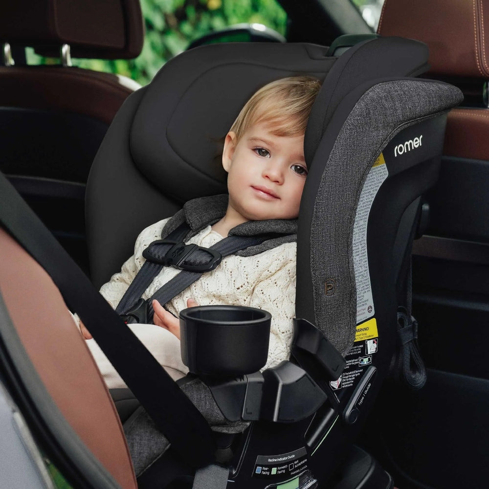 Romer Veni Convertible Car Seat in dark gray with cup holder, child seated securely in car.