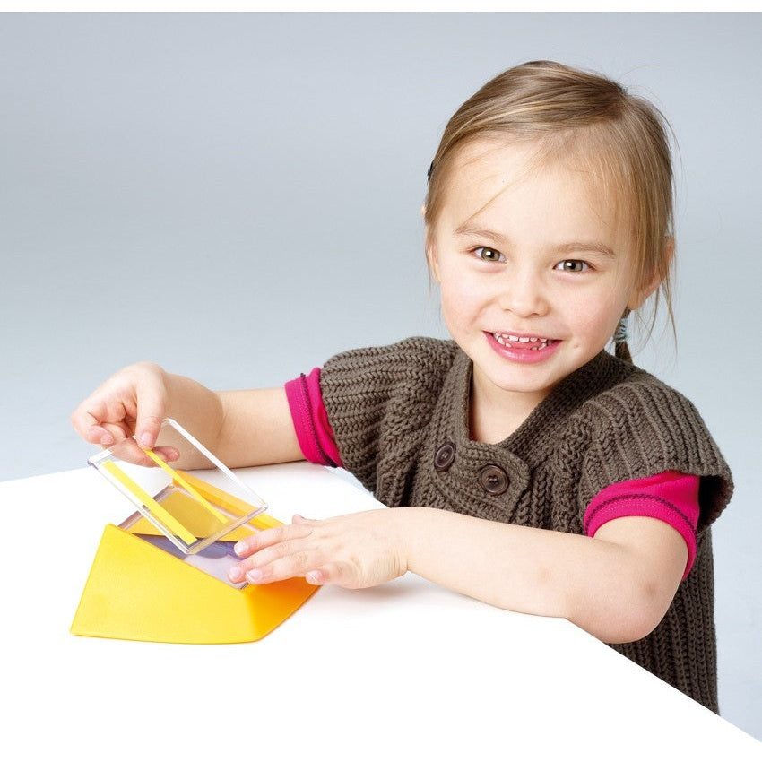 Smart Games Colour Code educational toy; toddler plays with yellow puzzle pieces on a white table