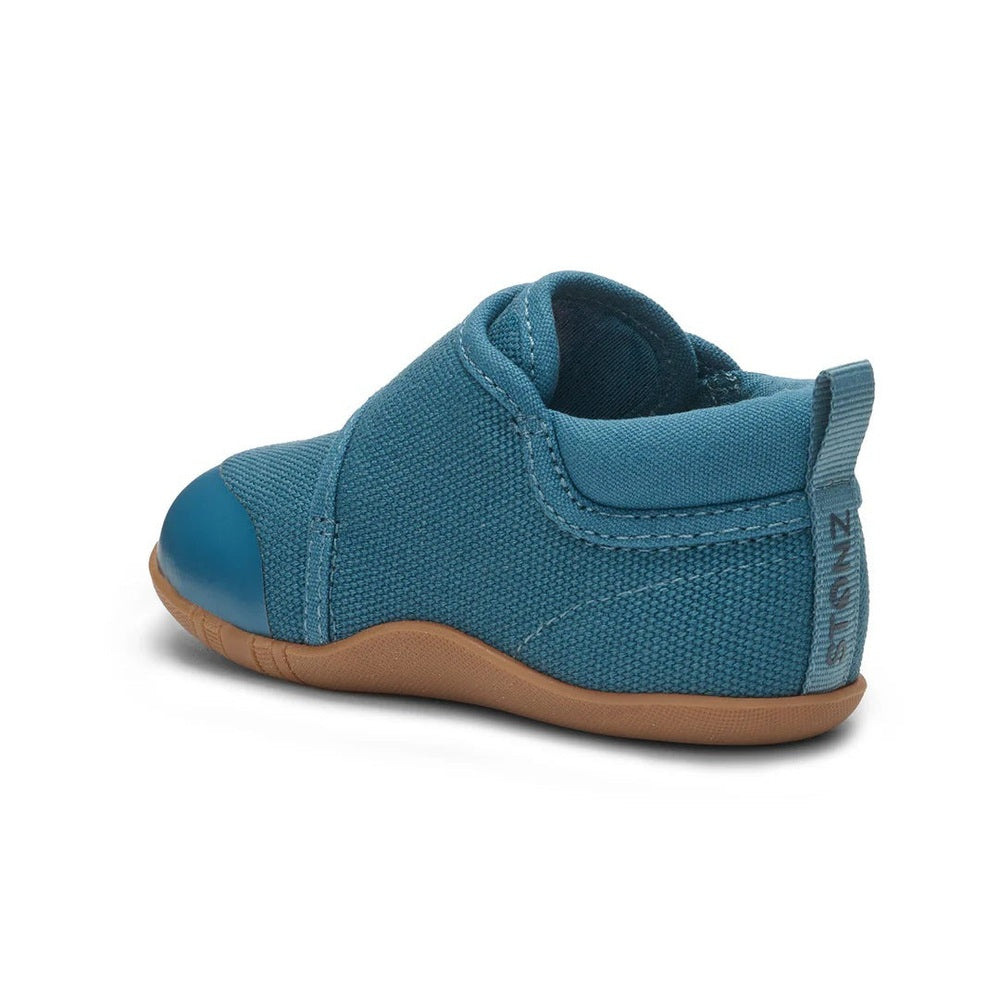 STONZ Cruiser Natural Baby Shoes Denim; blue denim sneaker with tan sole and back pull tab, shown as a toddler ready to walk