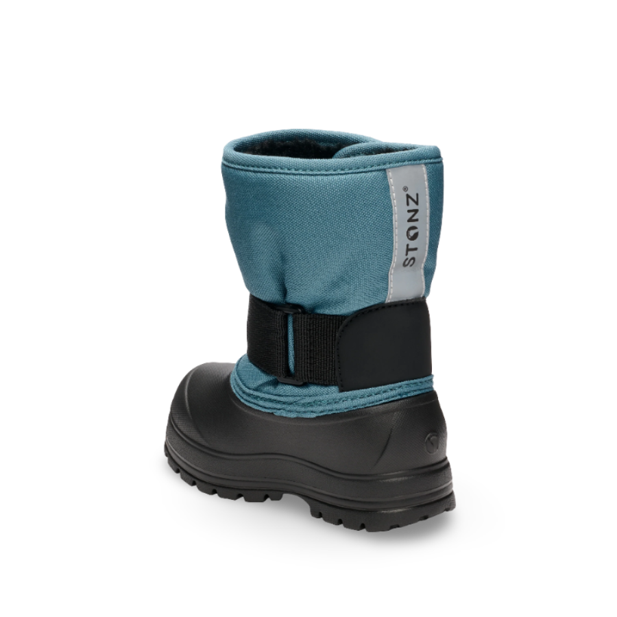 Stonz Trek Toddler Snow Boots Denim, a blue denim boot with a black sole and adjustable strap shown from the back.