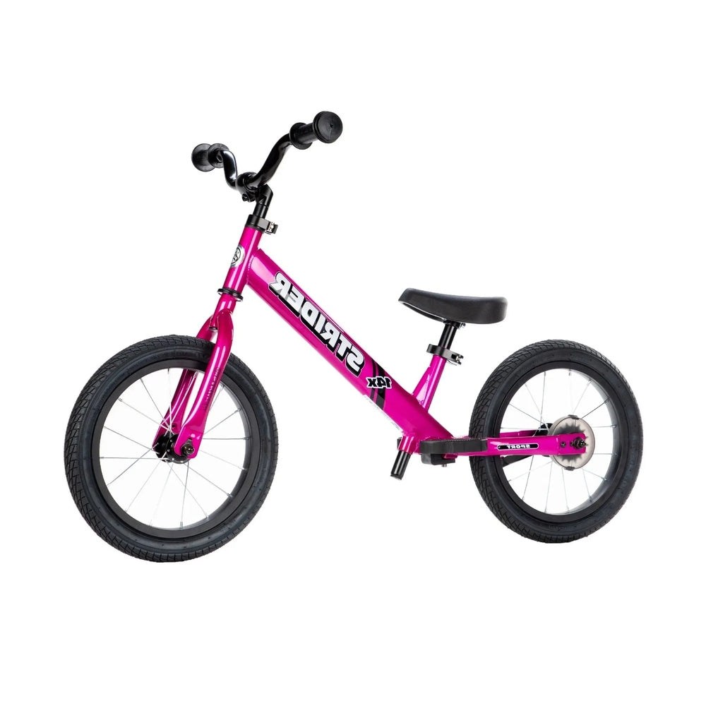 Strider 14X Classic Balance Bike in pink with black handlebars and seat, two wheels ready for a ride