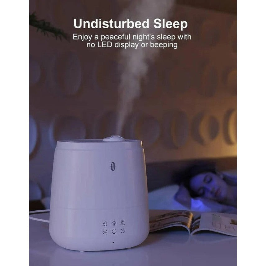 TaoTronics 6L Ultrasonic Humidifier in white emitting mist beside a sleeping person for quiet night comfort.