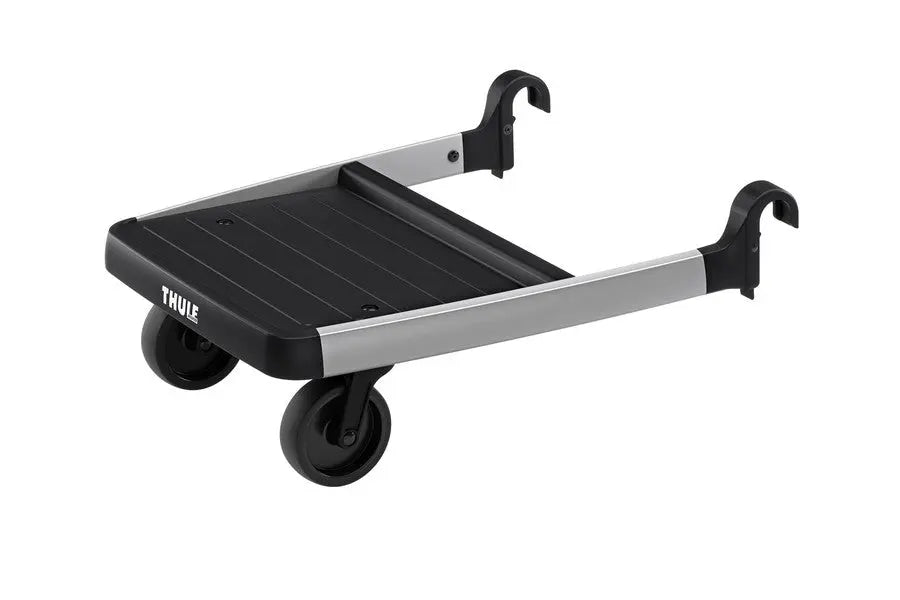 Thule Glider Board stroller accessory, black platform with silver rails and wheels, attached to a stroller