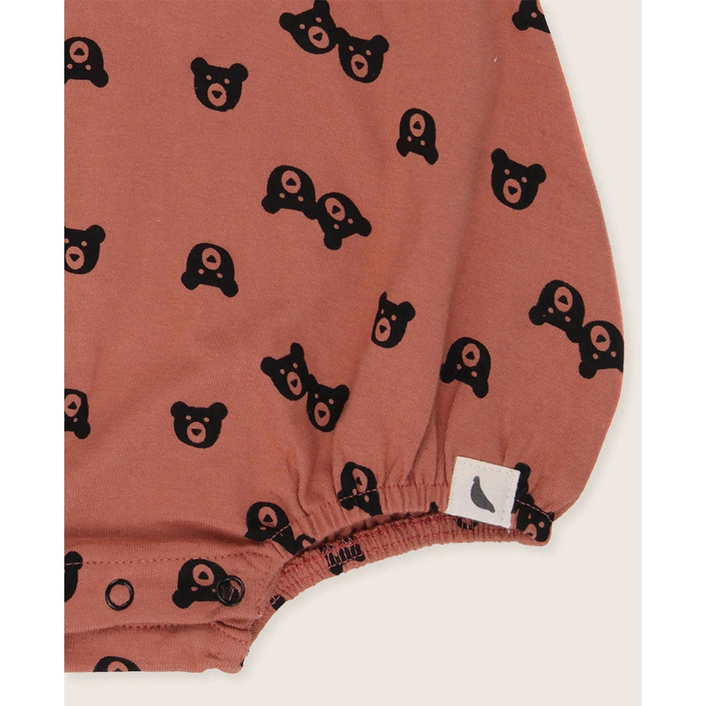 Turtledove London Two Bears Bubble Romper Sunset; rust fabric with black bears, elastic leg cuffs and snap closures.